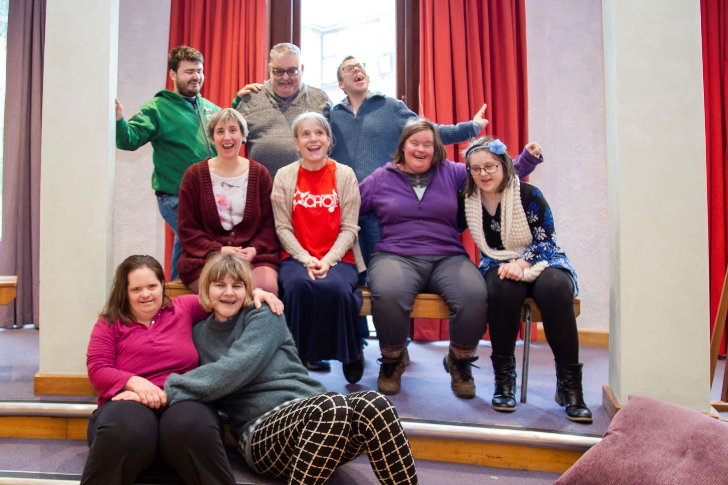 Group of people smiling and happy, sitting next to each other