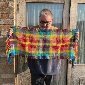 Someone holding up woven fabric