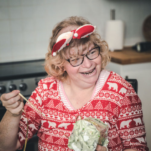 People with learning disabilities have skills to share. With your support we can help them shine. Lady making Christmas crafts and is smiling and happy