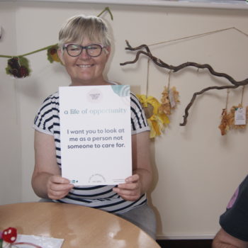 SONY DSC Girl being supported by a support worker to make a rang wreath