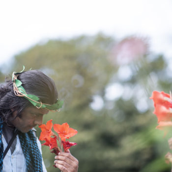A person we support smelling an orange flower