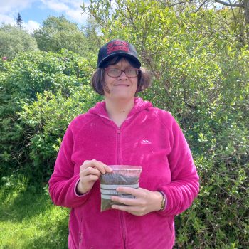 A person we support holding a soil sample