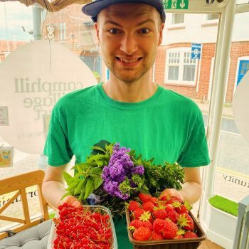 A person we support holding fruit and smiling