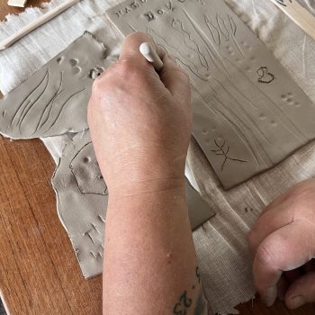 Someone drawing on clay