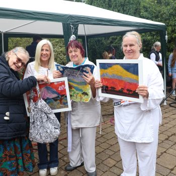 People we support and our CEO standing with art work