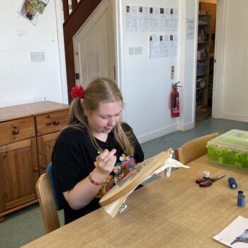 A person we support doing needlework in arts workshop