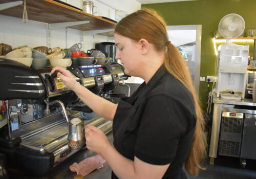 A person we support using the coffee machine