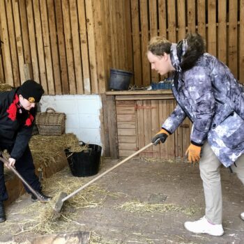People we support sweeping hay