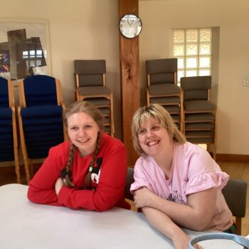 Two people we support sitting together