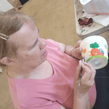 A person painting a mug