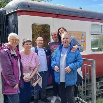 People standing by an old train