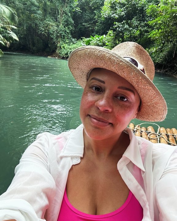 Caluette in a sunhat by a river