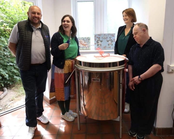 Four people stand next to a new kiln, a team member from Bell Group, a Great Pottery Throw Down contestant, a Camphill Village Trust team member, and person from the Croft Community. 