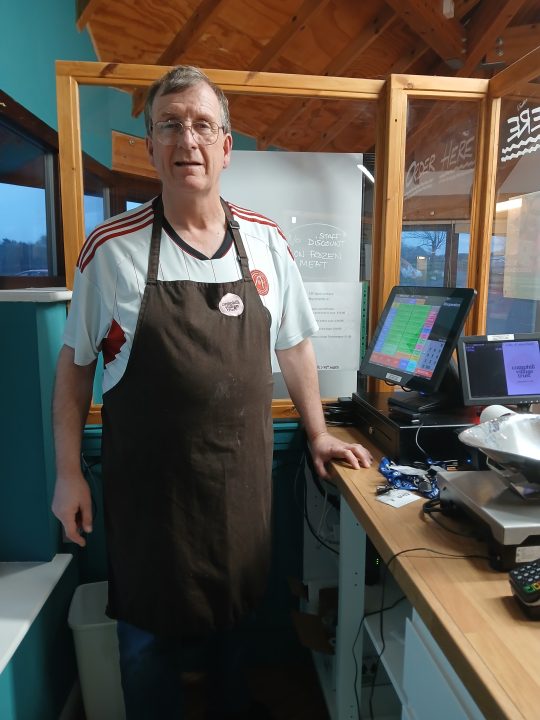 A person we support standing at the till