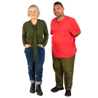 A female support worker stands next to a man she provides care to.