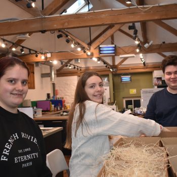 Three trainees inside at Severnside Skills they are packing boxes.