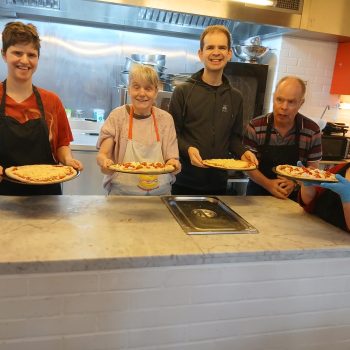 People holding food in a kitchen