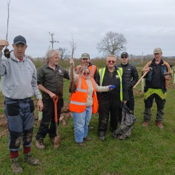 People smiling outside gardening