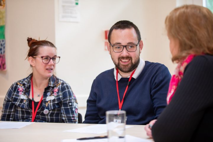 Two Life of Opportunity Reviewers talking to a Trustee at a table - they are smiling.