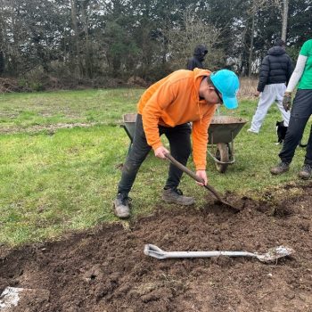 A person using a shovel in a garden