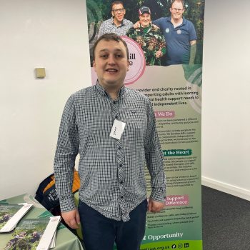 Simon standing next to a banner