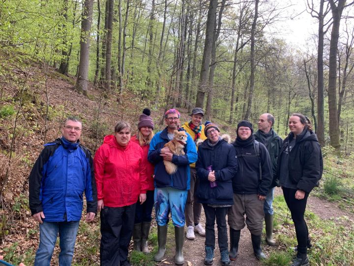 People walking in a forest with a therapy dog