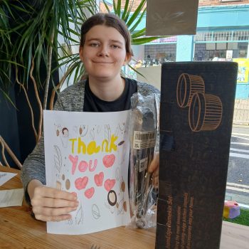 Someone smiling with a card and new cafe equipment