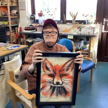 A person holding felted artwork