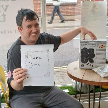 A person we support with a thank you sign