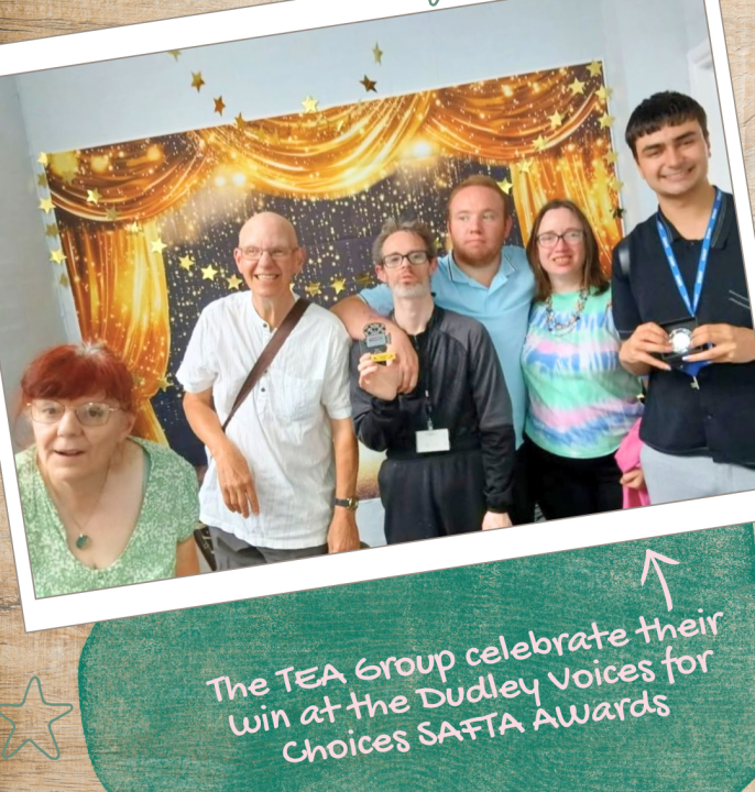 A group of six adults pose together in front of a gold-and-black awards backdrop decorated with stars and stage curtains. Two people in the centre hold award trophies. The image is presented as a tilted photograph on a textured background. Text at the bottom reads: “The TEA Group celebrate their win at the Dudley Voices for Choices SAFTA Awards.”