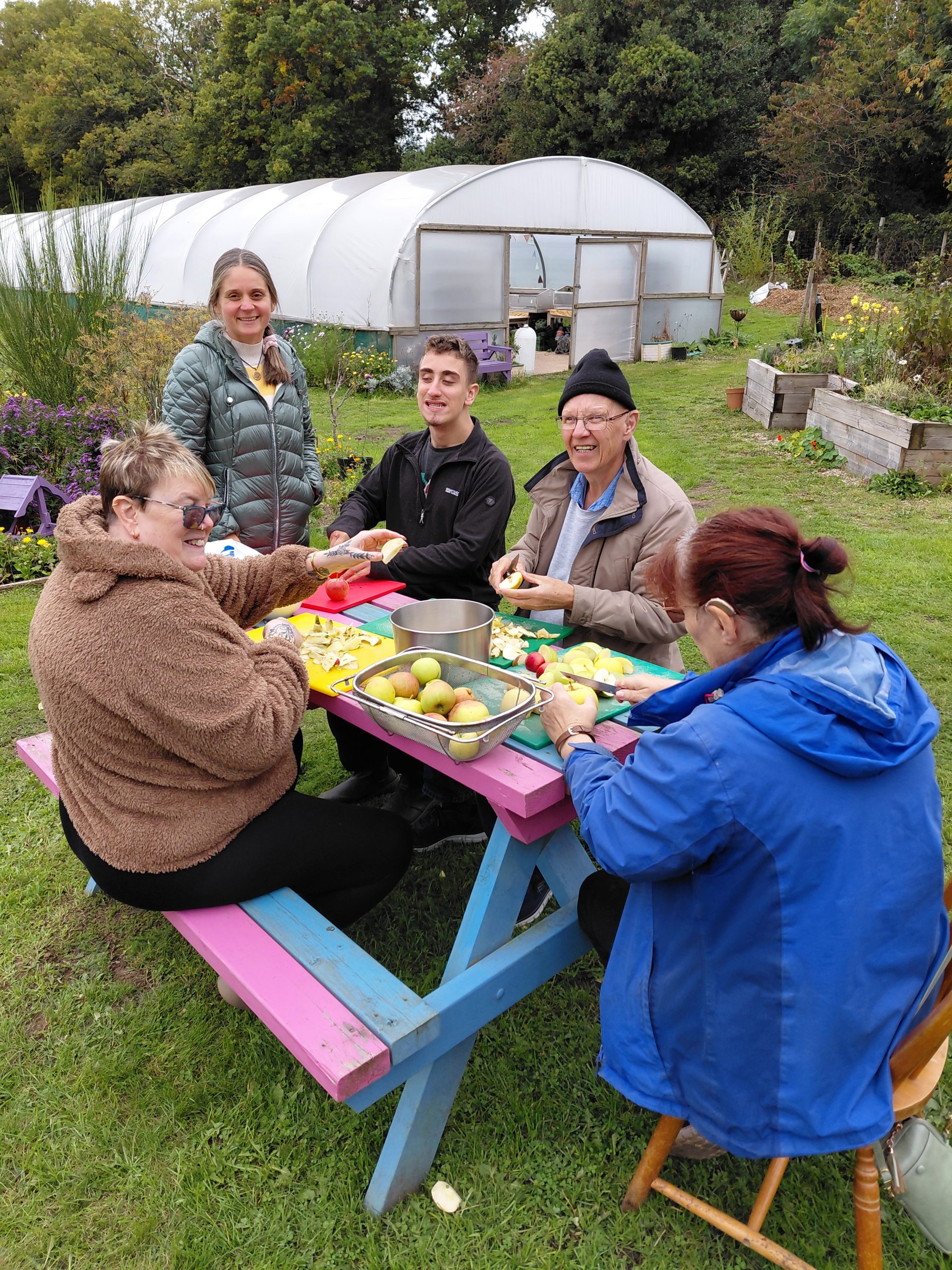 people working together in the garden at Ashfield Gardens, tending plants and sharing a gardening task in an outdoor community setting.