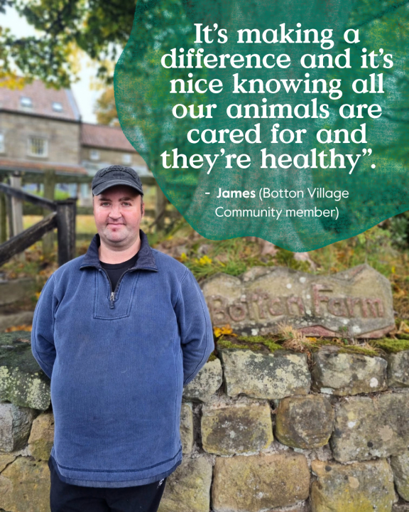 Community member James standing outside Botton Farm, where he helps care for the dairy herd that produces milk for Botton Village's award-winning cheeses.