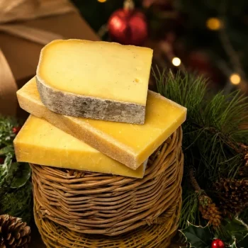 Three cheeses on a wicker basket in front of a festive background